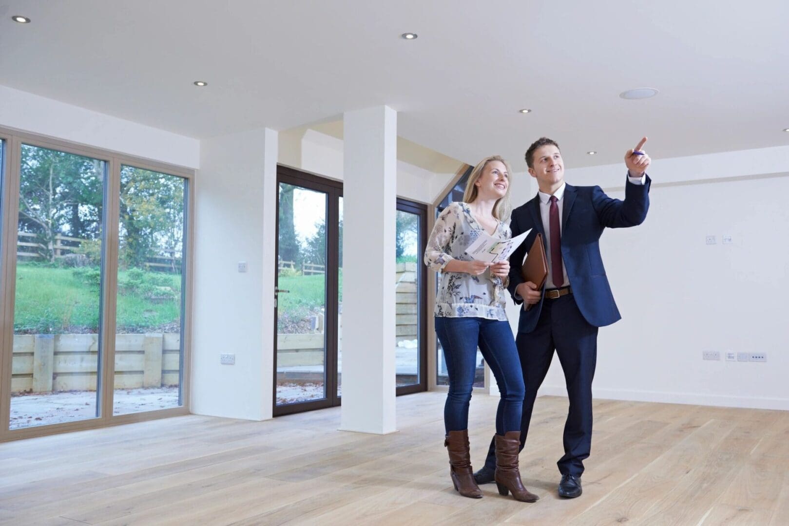 A man and woman are looking at something in the house.