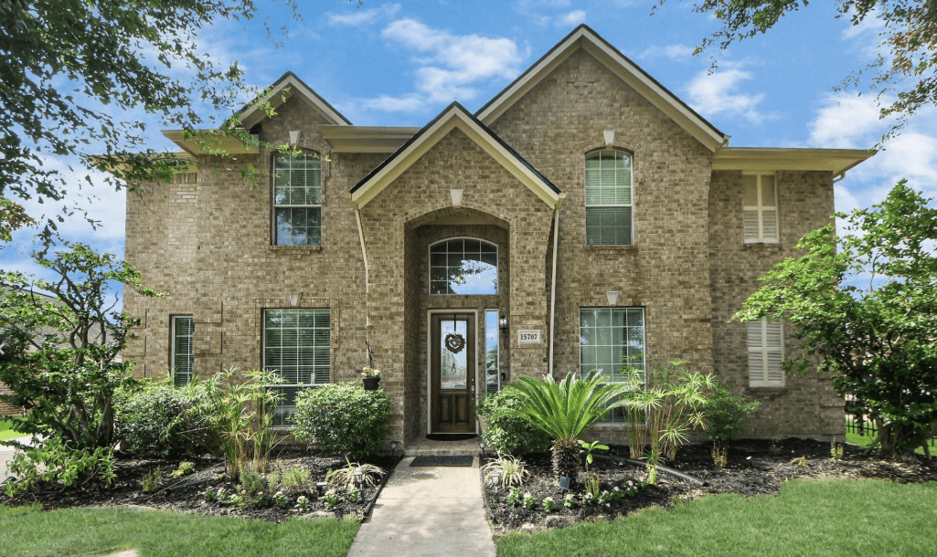 Two-story brick suburban house with landscaped yard