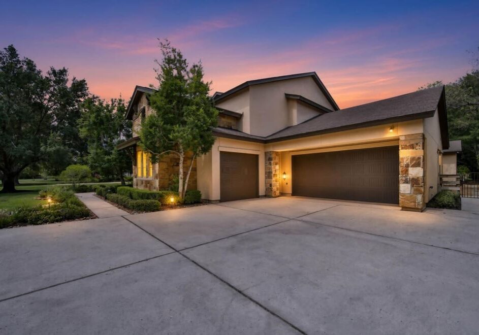 Modern house exterior at sunset with greenery.