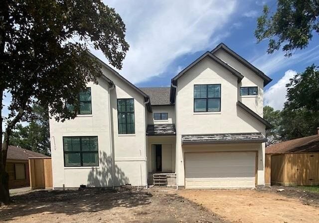 A house with a garage and trees in the background.